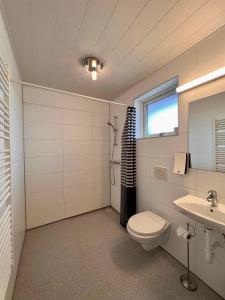 La salle de bains est pourvue de toilettes et d'un lavabo. dans l'établissement Guesthouse Nypugardar, à Höfn
