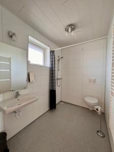 La salle de bains est pourvue d'un lavabo et de toilettes. dans l'établissement Guesthouse Nypugardar, à Höfn