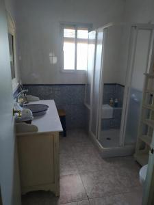 a white bathroom with a sink and a shower at Casa Rural Tazgona in Antequera