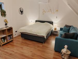 una camera con un letto e un divano blu di Orsika HillTop Apartman a Eger