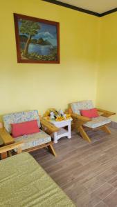 a room with two benches and a table and a painting at Tropical Paradise View in Anse La Raye