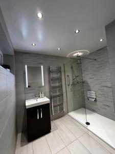 a bathroom with a shower and a sink and a mirror at The Eves in Corbridge