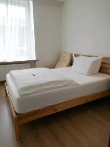 Bett mit weißer Bettwäsche und Kissen in einem Zimmer in der Unterkunft Hotel Hanseatic-garni in Wuppertal