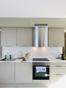 a kitchen with white cabinets and a stove top oven at Leilighet ved Slottsfjellet in Tønsberg