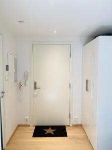 una habitación con una puerta blanca con una estrella sobre una alfombra en Leilighet ved Slottsfjellet, en Tønsberg