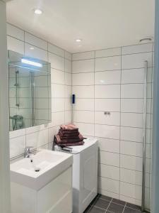 a white bathroom with a sink and a mirror at Leilighet ved Slottsfjellet in Tønsberg