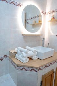 a bathroom with a sink and a mirror and towels at 3 pièces au cœur du cros de cagnes in Cagnes-sur-Mer +13 photos