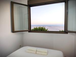 a bedroom with a window with towels on a bed at Villa Brisita in Granadilla de Abona