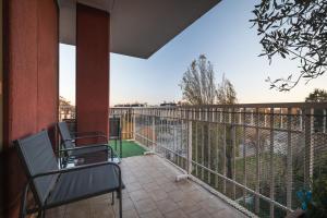 een balkon met 2 stoelen en een hek bij Apartment Forum IV in Assago