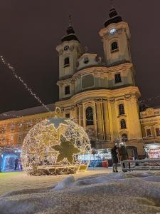 Un edificio con una torre dell'orologio con un ornamento natalizio di Orsika HillTop Apartman a Eger