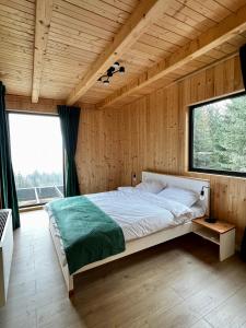 een slaapkamer met een groot bed in een houten kamer bij Cabana Merlin - Statiunea Muntele Baisorii in Cluj-Napoca