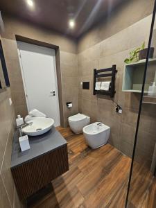 a bathroom with two sinks and a toilet at San Benedetto Rooms in Crema
