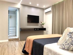 a hotel room with a bed and a flat screen tv at Espaçoso, moderno e excelente localização in Belém