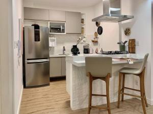 eine Küche mit einem Kühlschrank aus Edelstahl und einer Theke in der Unterkunft Espaçoso, moderno e excelente localização in Belém + 15 Fotos