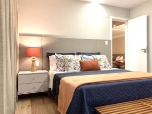 a bedroom with a large bed with a blue comforter at Espaçoso, moderno e excelente localização in Belém