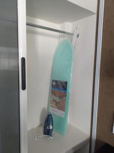 a surfboard on a shelf in a white cabinet at Departamento centro Zihuatanejo in Zihuatanejo