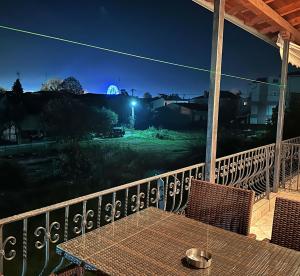 a table and chairs on a balcony at night at Living Home Trikala in Tríkala