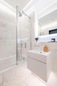 baño blanco con ducha y lavamanos en Immaculate 3 Bed Apartment with Private Entrance in Inverleith, en Edimburgo