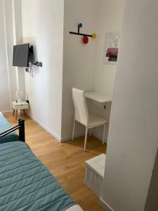 a bedroom with a bed and a desk with a computer at Ada's House in Alghero