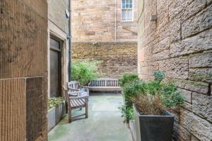 a courtyard with two benches in a building at Immaculate 3 Bed Apartment with Private Entrance in Inverleith in Edinburgh