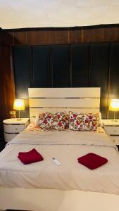 a large bed with two red pillows on it at Formidable of Cairo in Cairo