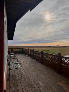 two benches sitting on the deck of a house at Guesthouse Nypugardar in Höfn