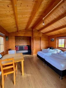 a room with two beds and a wooden ceiling at Guesthouse Nypugardar in Höfn