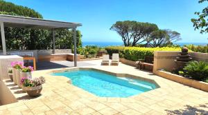 a backyard with a swimming pool and a patio at HORIZON BAY - Camps Bay in Cape Town