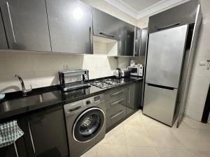 a kitchen with a washing machine and a refrigerator at Riverside 2 in Tétouan