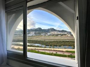 an arched window with a view of the mountains at Riverside 2 in Tétouan