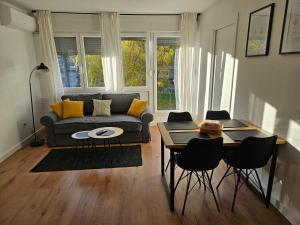 a living room with a couch and a table and chairs at Land Apartments in Zagreb
