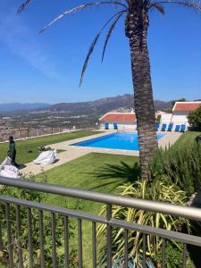 a view from the balcony of a villa with a palm tree at Appartement Duplex Rosas avec terrasse magnifique jacuzzi vue mer in Roses