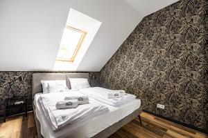 1 dormitorio con 1 cama con toallas en StoneHill24 - Apartament & Spa, en Szklarska Poręba
