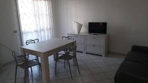 - un salon avec une table, des chaises et une télévision dans l'établissement Casa Nina, à Borgo a Giovi