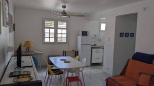 a living room with a table and a kitchen at Oxygène, Havre de paix in Les Anses-dʼArlets