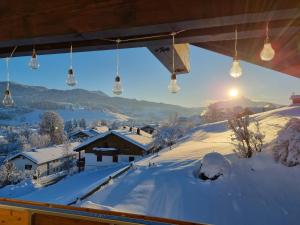 Ferienwohnung - Haus am Sonnenhang في فيرتاخ: إطلالة على قرية مغطاة بالثلج مع أضواء