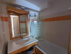 a bathroom with a sink and a mirror and a tub at Appartement Chamrousse, 4 personnes - Village du Bachat in Chamrousse