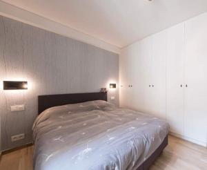 ein Schlafzimmer mit einem großen Bett und zwei Leuchten in der Unterkunft Hotel Ter Streep in Ostende