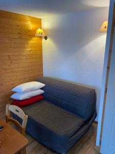 a bed in a room with a wooden wall at Appartement Chamrousse, 4 personnes - Village du Bachat in Chamrousse