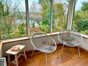 two chairs and a table in a room with windows at Foyleview Villa in Derry Londonderry