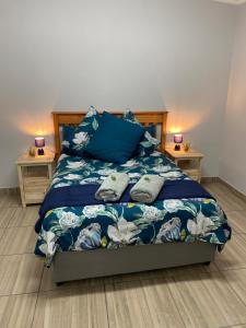 a bedroom with a blue bed with two night stands at The Old Fort in Aberdeen