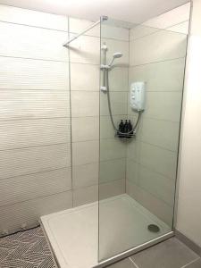 a shower with a glass door in a bathroom at Foyleview Villa in Derry Londonderry