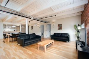 a living room with black furniture and a table at Les Lofts de la Barricade - Par les Lofts Vieux-Québec in Quebec City