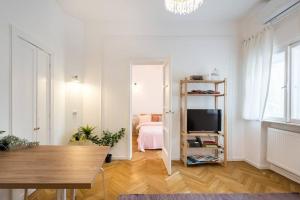 uma sala de estar com televisão e um quarto em Downtown Cozy Apartment Old Town em Bucareste