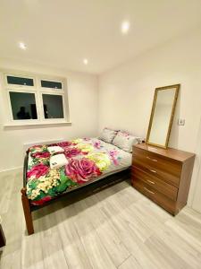 a bedroom with a bed with a dresser and a mirror at Lovely One bed apartment In London in London