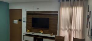 Apto em João Pessoa wifi e ar condicionado في جواو بيسوا: غرفة معيشة فيها تلفزيون على جدار