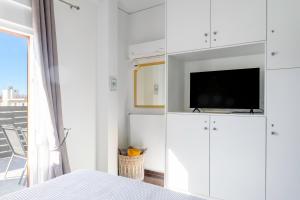a bedroom with white cabinets with a tv on top at The Owl - Stylish Penthouse - Gazi 1BDRM in Athens
