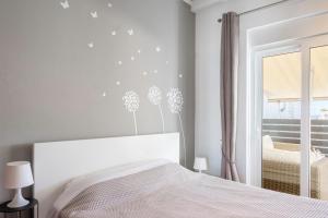 a white bedroom with a bed and a window at The Owl - Stylish Penthouse - Gazi 1BDRM in Athens