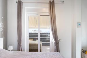 um quarto com uma porta que abre para uma varanda em The Owl - Stylish Penthouse - Gazi 1BDRM em Atenas