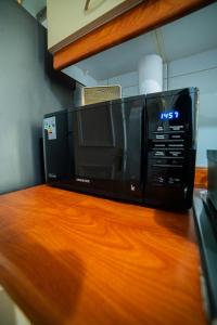 a microwave sitting on top of a wooden counter at Full departamento, Metro Manquehue, Las Condes in Santiago